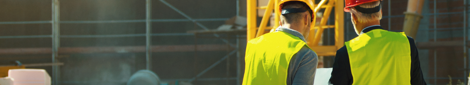 Two men wearing hard hats and high vis jackets