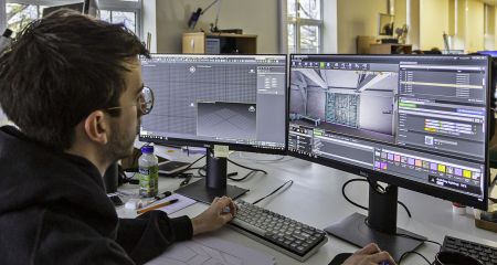 An computer technician works on a 3D visualisation of a historic building.