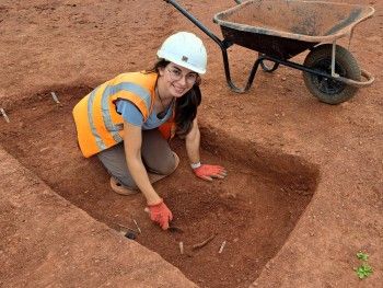 Photograph of Laura Beckwith excavating a slot with a trowel