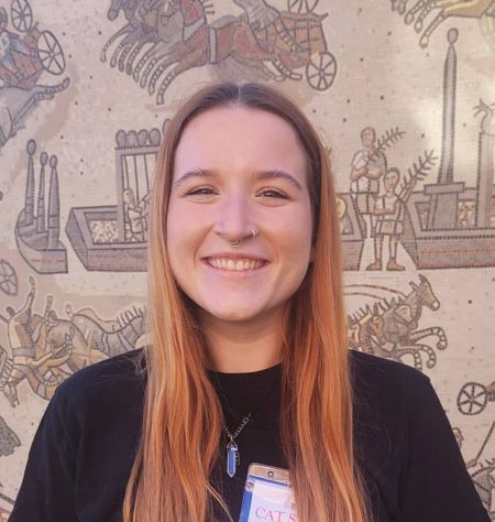 Victoria Sands in front of a mural showing Roman chariot racing