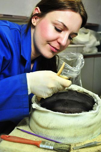 An archaeologist undertakes analysis on recovered materials.