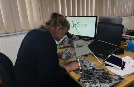 A woman sits at a desk in front of a computer.