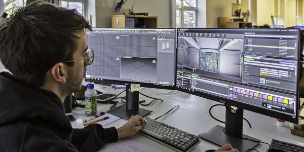 An computer technician works on a 3D visualisation of a historic building.