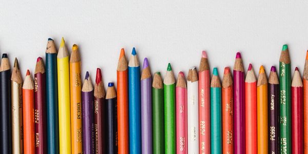 Coloured pencils of various lengths are arranged alongside each other.