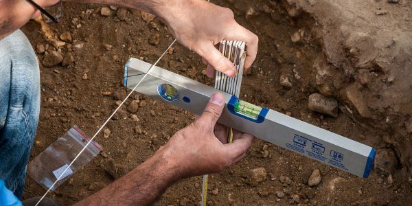 Recording an archaeological feature using a section line and spirit level.
