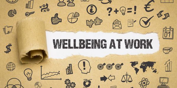 Brown paper with decorations is torn back to reveal the words 'wellbeing at work'.