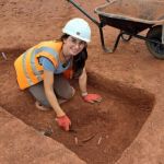 Photograph of Laura Beckwith excavating a slot with a trowel