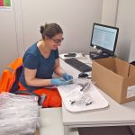 Sue McGalliard sits at a desk and works with ancient bone fragments.